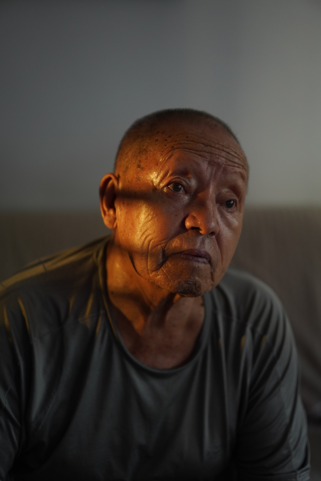 A seated person lit softly against a dark background.